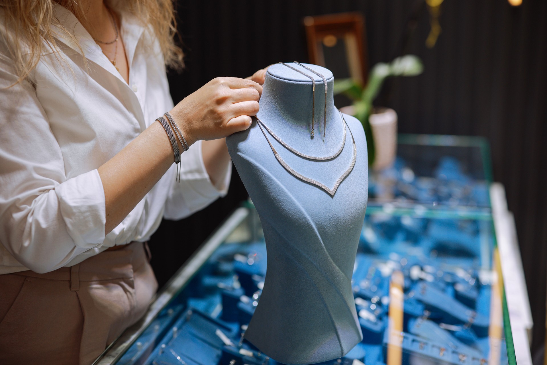 Woman owner of jewelry shop presenting necklace